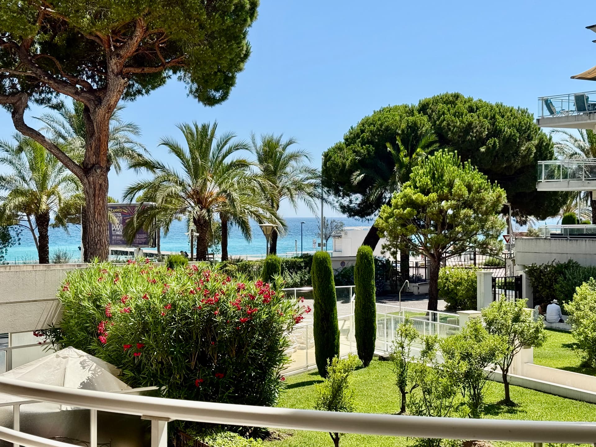 Vue mer depuis un balcon de la Résidence Royal Palm à Cannes-la-Bocca, jardins et pins parasols